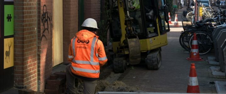a construction worker standing next to a construction truck